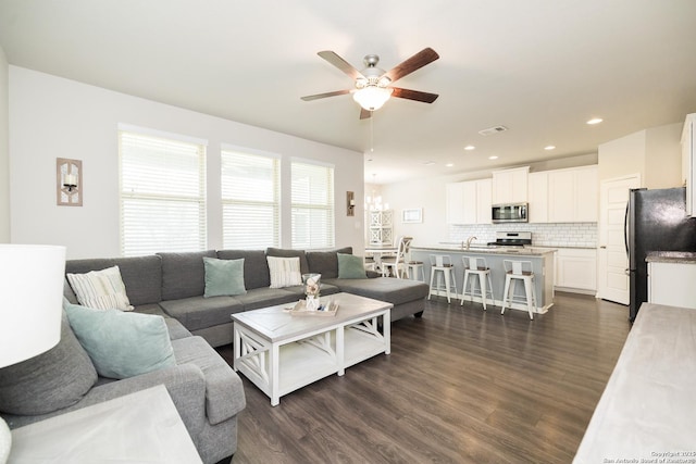 living room featuring ceiling fan, sink, and dark hardwood / wood-style flooring