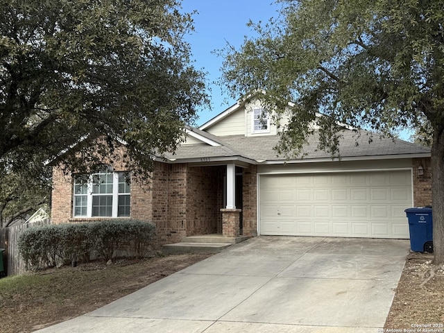 view of front of home with driveway, roof with shingles, a garage, and brick siding