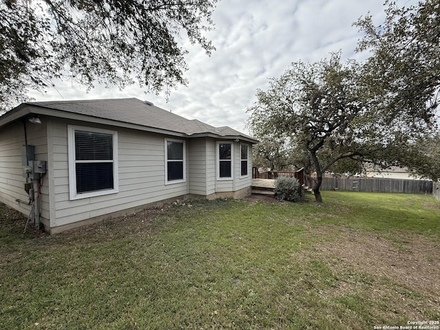 back of house featuring a lawn and a wooden deck