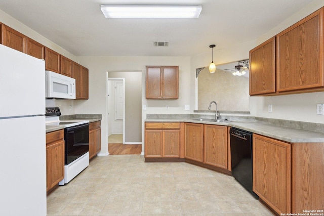 kitchen with pendant lighting, light countertops, visible vents, a sink, and white appliances