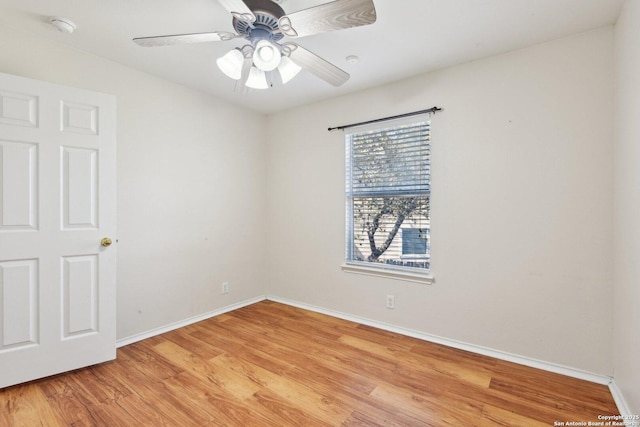 spare room featuring a ceiling fan, light wood-type flooring, and baseboards