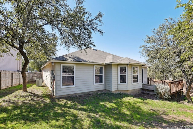 back of house with a deck, a lawn, cooling unit, and fence