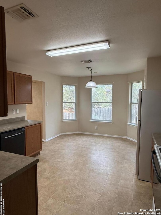 kitchen featuring white fridge, black dishwasher, pendant lighting, a healthy amount of sunlight, and range