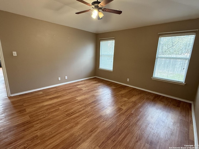 unfurnished room featuring ceiling fan, a wealth of natural light, and hardwood / wood-style floors