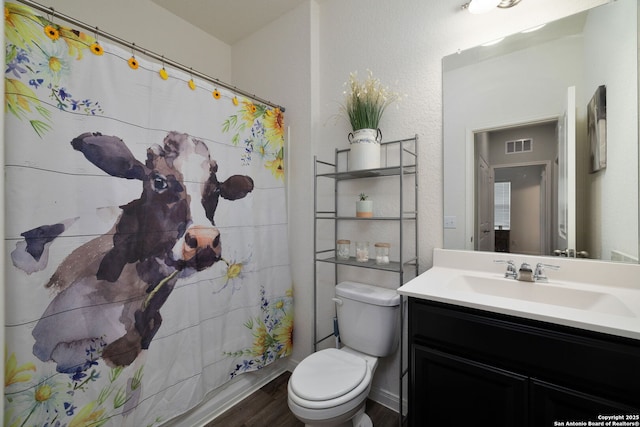 bathroom with hardwood / wood-style flooring, vanity, and toilet