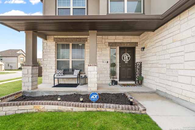 view of exterior entry featuring covered porch