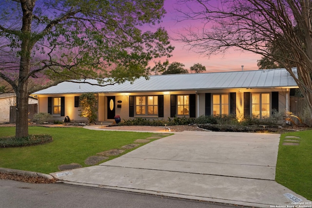 single story home featuring a lawn