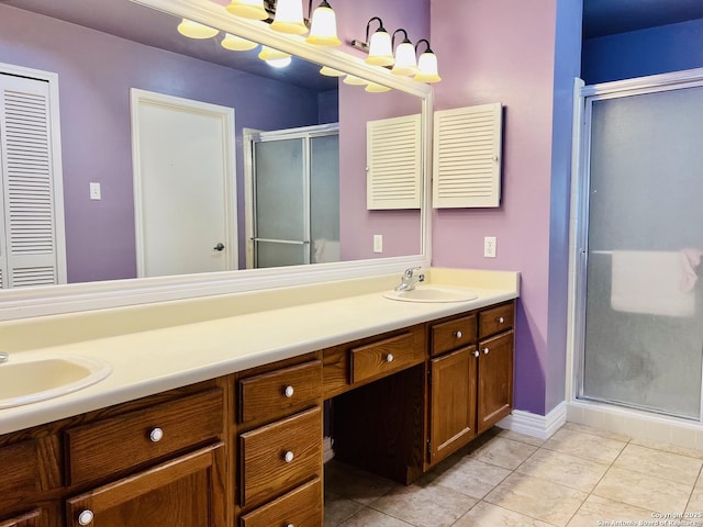 bathroom with tile patterned flooring, vanity, and a shower with door