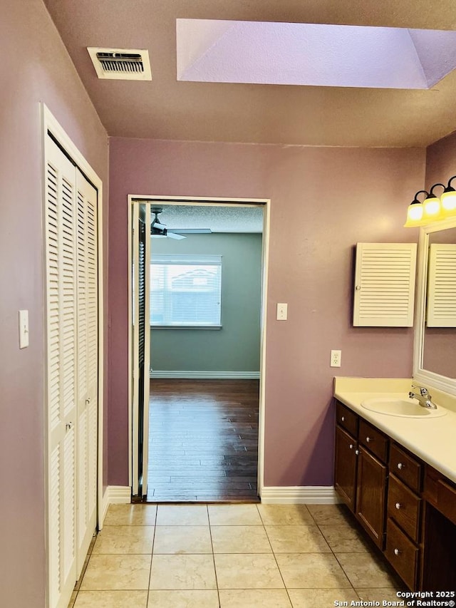 bathroom with ceiling fan, tile patterned flooring, and vanity