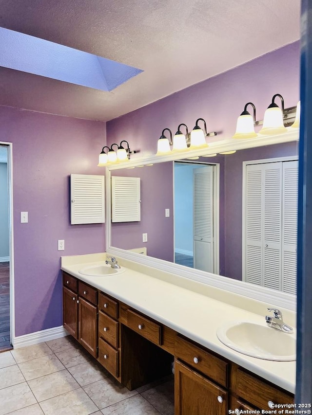 bathroom with a textured ceiling, vanity, and tile patterned flooring