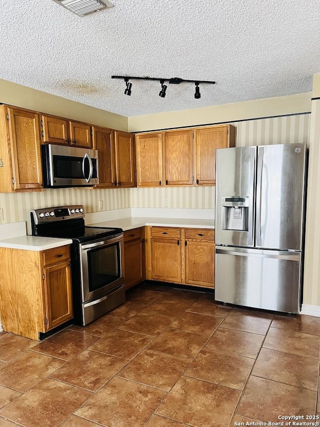 kitchen with appliances with stainless steel finishes and a textured ceiling