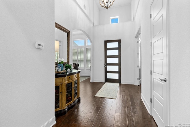 foyer featuring a high ceiling, dark hardwood / wood-style floors, and an inviting chandelier