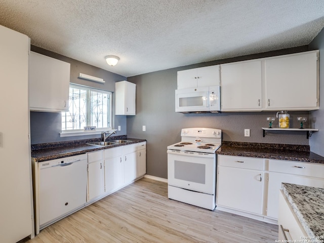 kitchen featuring white cabinetry, white appliances, and sink