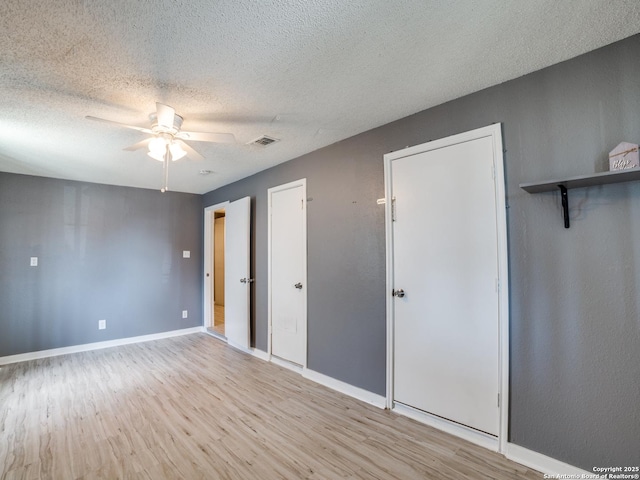 unfurnished bedroom with a textured ceiling, ceiling fan, and light hardwood / wood-style floors