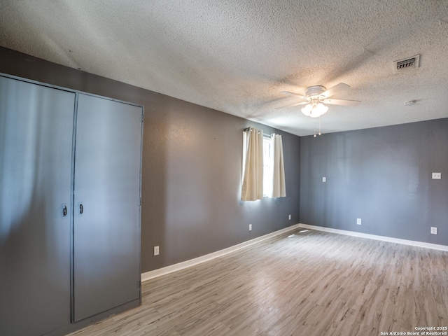 unfurnished bedroom featuring ceiling fan, light hardwood / wood-style flooring, a textured ceiling, and a closet