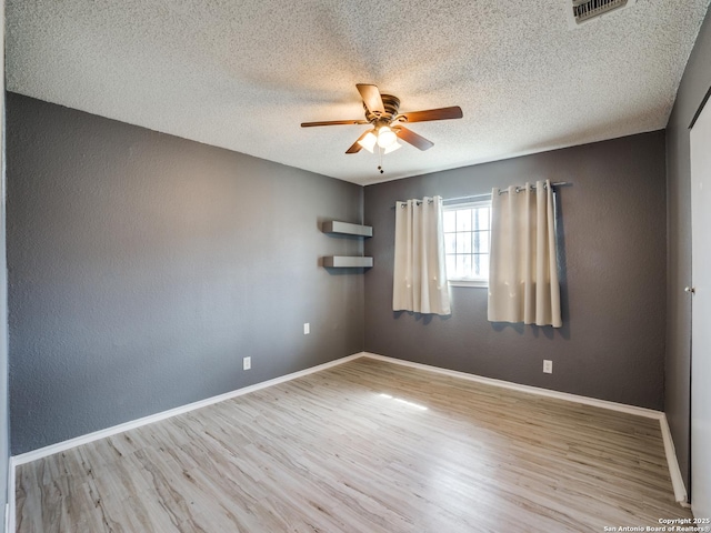 unfurnished room with ceiling fan, a textured ceiling, and light hardwood / wood-style floors