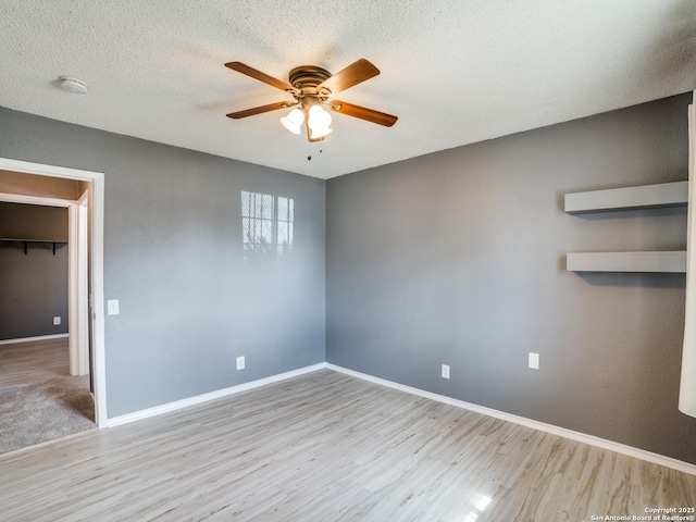 unfurnished room featuring light hardwood / wood-style floors, ceiling fan, and a textured ceiling