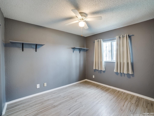 empty room featuring light wood-type flooring, ceiling fan, and a textured ceiling