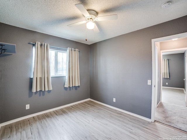 empty room with light wood-type flooring, a textured ceiling, and ceiling fan