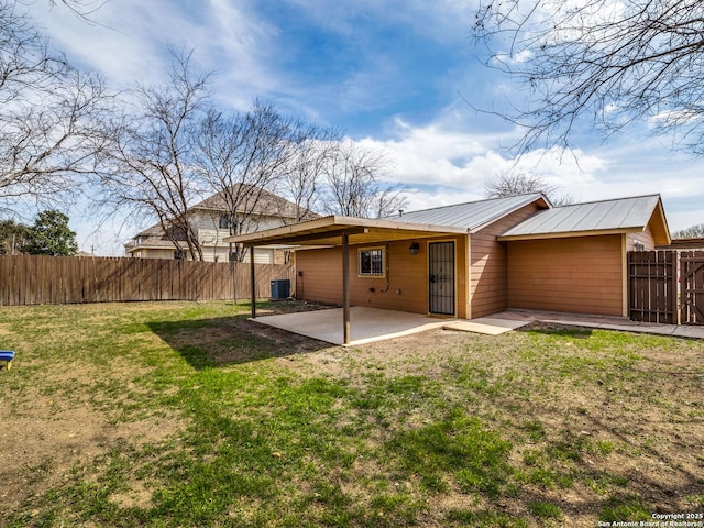 rear view of property with central air condition unit, a patio, and a lawn