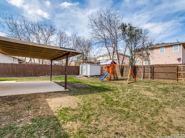 view of yard with a patio, a playground, and a storage shed