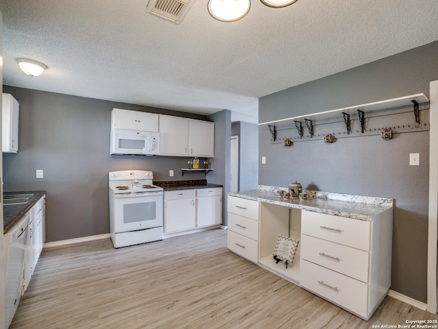 kitchen featuring white appliances, a textured ceiling, white cabinets, light hardwood / wood-style floors, and sink