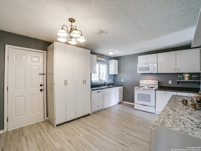 kitchen featuring hanging light fixtures, white appliances, a textured ceiling, light hardwood / wood-style floors, and white cabinetry