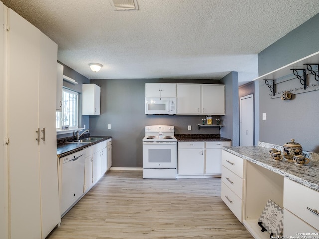 kitchen featuring white appliances, white cabinetry, sink, and light hardwood / wood-style flooring