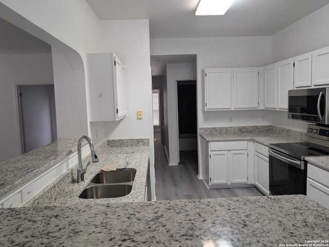 kitchen featuring light hardwood / wood-style flooring, sink, stainless steel appliances, white cabinets, and light stone countertops