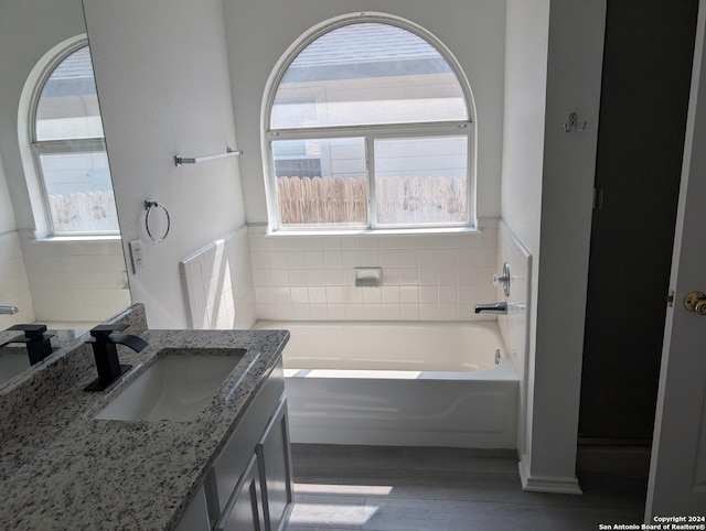 bathroom featuring vanity, hardwood / wood-style floors, and a bathtub