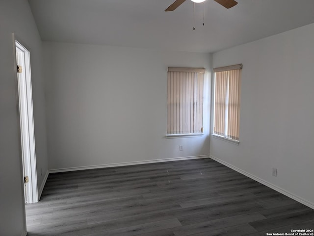 spare room with dark hardwood / wood-style flooring and ceiling fan