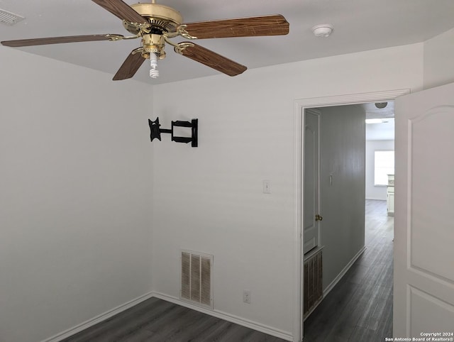 empty room with dark hardwood / wood-style floors and ceiling fan