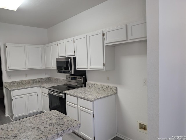 kitchen featuring white cabinetry, stainless steel appliances, and light stone countertops