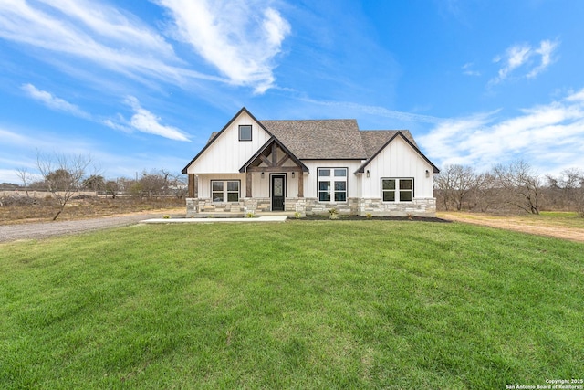 modern farmhouse with driveway, stone siding, board and batten siding, and a front yard