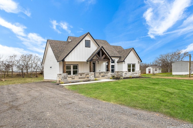 modern inspired farmhouse featuring stone siding, roof with shingles, board and batten siding, and a front yard