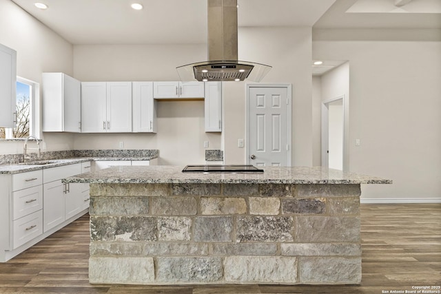 kitchen with a sink, a center island, white cabinets, light stone countertops, and island exhaust hood