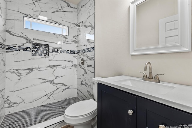 bathroom featuring a shower stall, toilet, and vanity