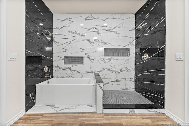 bathroom with a shower, a garden tub, and wood finished floors