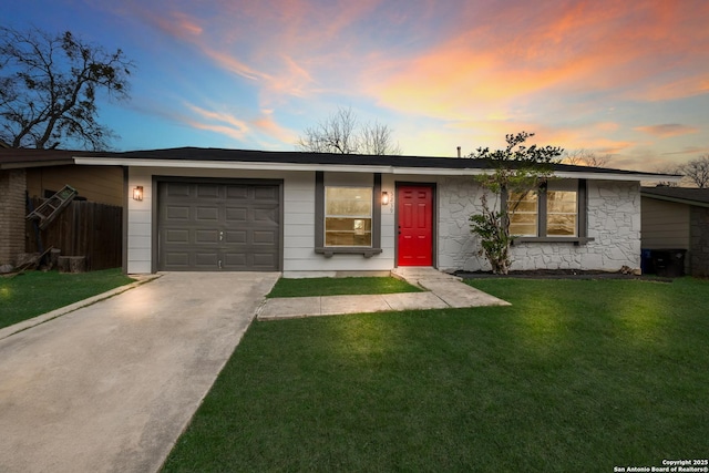 ranch-style house featuring a garage and a yard