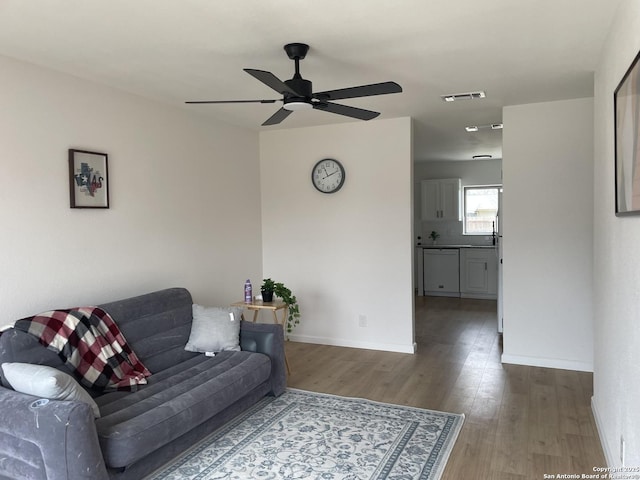 living room featuring ceiling fan and dark hardwood / wood-style floors