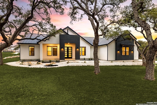 view of front facade with a yard and french doors