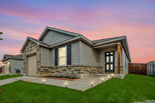 ranch-style house featuring a front yard, a garage, stone siding, and fence