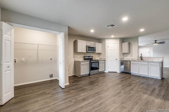 kitchen with appliances with stainless steel finishes, a sink, dark wood-type flooring, and visible vents