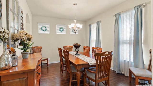 dining room with a notable chandelier, baseboards, a healthy amount of sunlight, and dark wood-type flooring