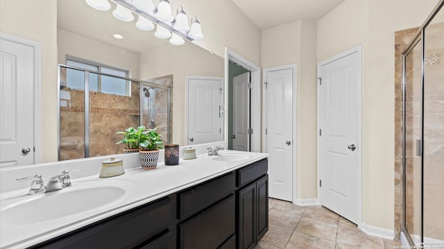 full bath with tile patterned floors, a stall shower, double vanity, and a sink