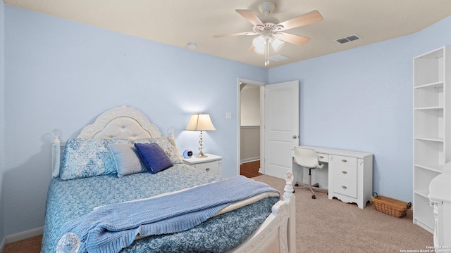 bedroom with light carpet, a ceiling fan, and visible vents