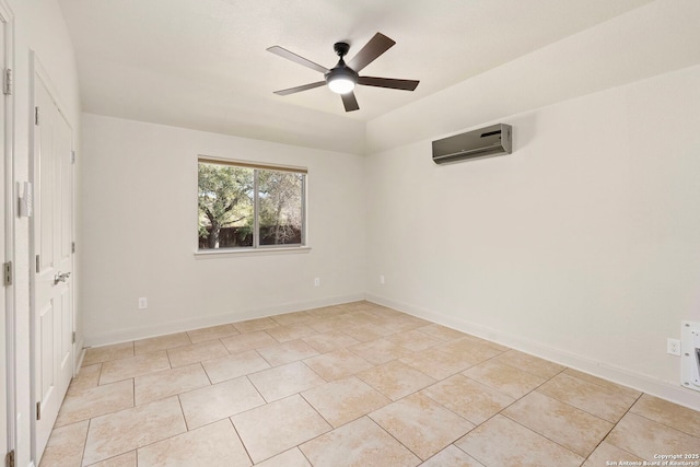 spare room with baseboards, a wall mounted air conditioner, ceiling fan, and light tile patterned floors