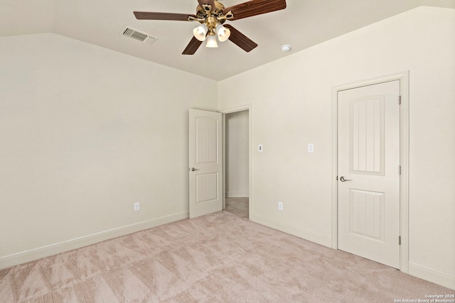 unfurnished bedroom featuring ceiling fan, light carpet, baseboards, vaulted ceiling, and visible vents