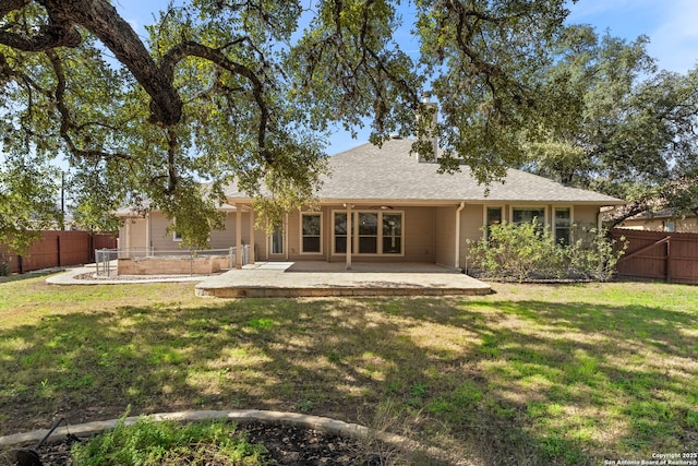 back of house with a patio area, a lawn, a shingled roof, and a fenced backyard