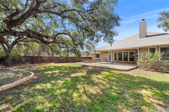 view of yard featuring a patio area, ceiling fan, and a fenced backyard